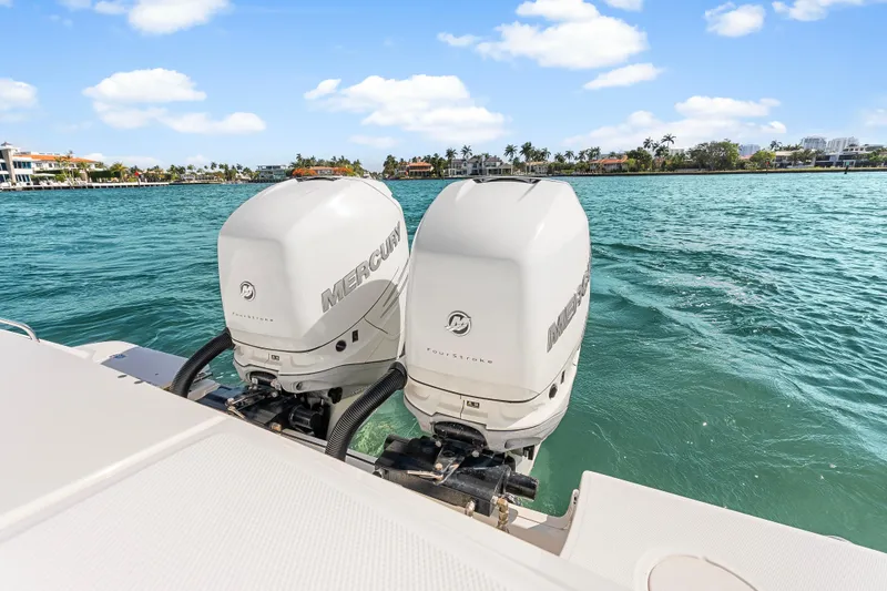 Slide: The Image of Twin Mercury outboard engines on a 2017 Boston Whaler 330 Outrage, with scenic waterfront view. - 34
