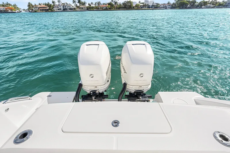 Slide: The Image of 2017 Boston Whaler 330 Outrage with twin outboard engines on turquoise water. - 35