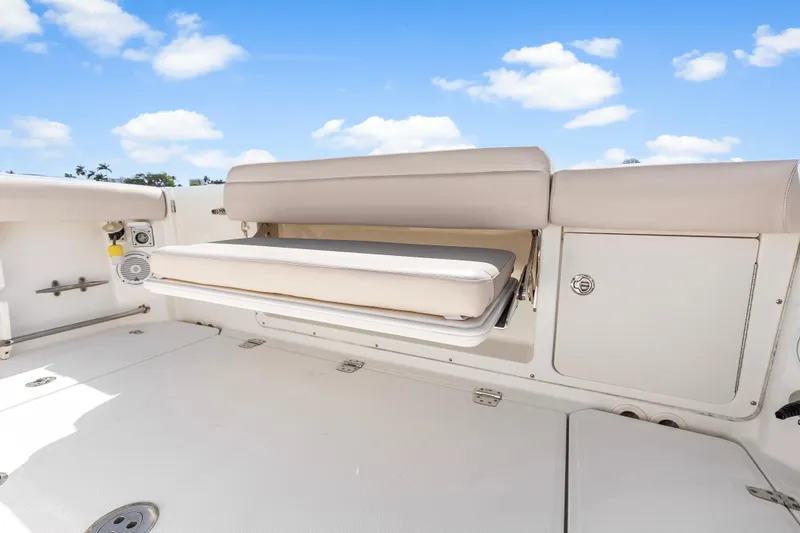 Slide: The Image of 2017 Boston Whaler 330 Outrage boat interior with foldable seating and storage compartments. - 39