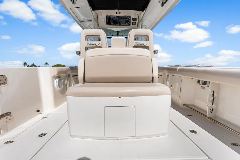 Slide: The Image of 2017 Boston Whaler 330 Outrage boat interior with seating and storage, under a clear blue sky. - 41