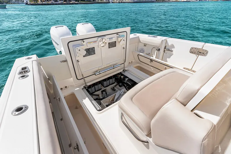 Slide: The Image of 2017 Boston Whaler 330 Outrage boat interior with open storage compartment, on clear blue water. - 47