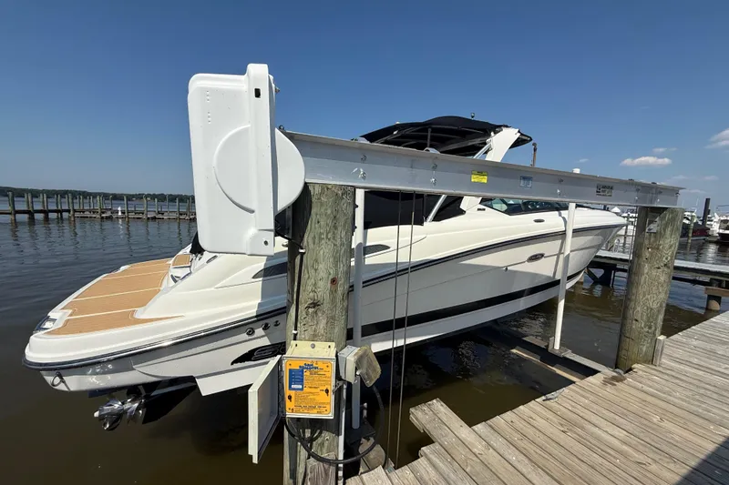 Slide: The Image of 2011 Sea Ray 270 SLX boat on lift at marina dock under clear sky. - 1