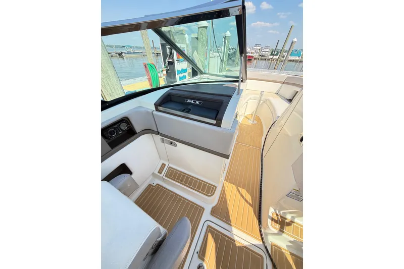 Slide: The Image of Interior view of 2011 Sea Ray 270 SLX boat with wooden flooring at a marina. - 19