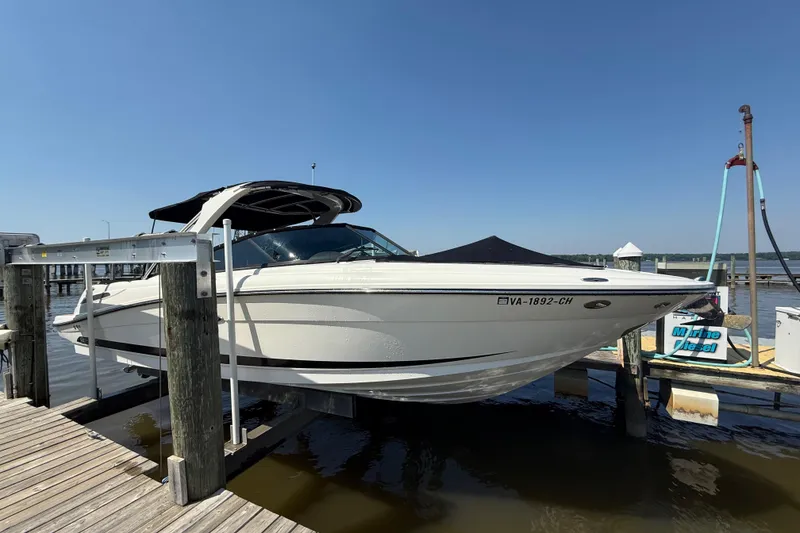Slide: The Image of 2011 Sea Ray 270 SLX boat docked at a marina under clear blue skies. - 2