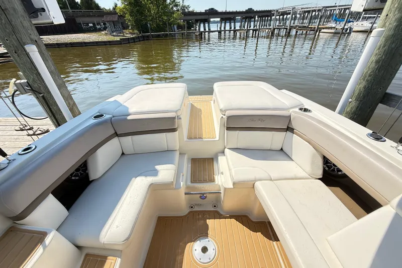 Slide: The Image of 2011 Sea Ray 270 SLX boat interior with beige seating, docked by the water. - 29