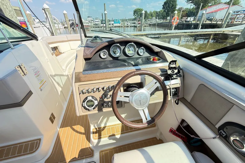 Slide: The Image of Interior view of 2011 Sea Ray 270 SLX boat cockpit with steering wheel and controls. - 31