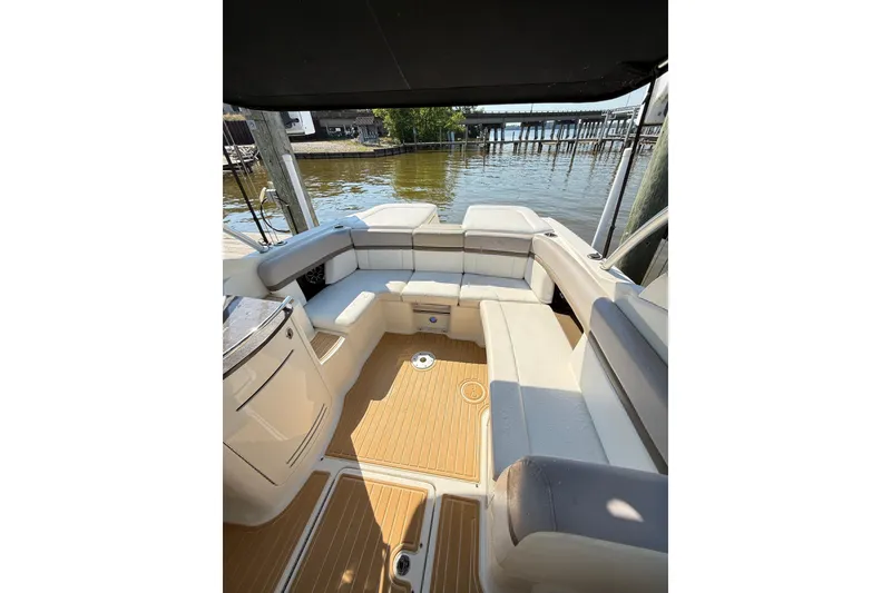 Slide: The Image of 2011 Sea Ray 270 SLX boat interior with cushioned seating and wooden flooring. - 36