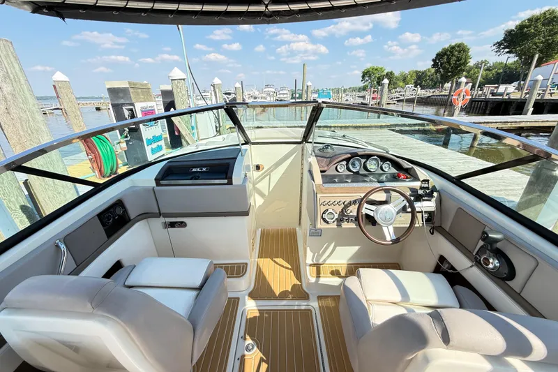Slide: The Image of Interior view of 2011 Sea Ray 270 SLX boat at dock, featuring helm and seating. - 38