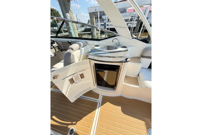 Slide: The Image of 2011 Sea Ray 270 SLX boat interior with sink, seating, and open storage compartment. - 43