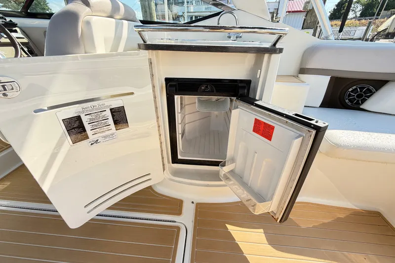 Slide: The Image of Open mini fridge on 2011 Sea Ray 270 SLX boat, showcasing interior and seating area. - 45