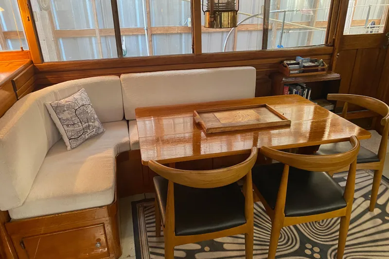 Slide: The Image of Interior of a 1939 Elco Motor Yacht with wooden dining table and cushioned seating. - 11