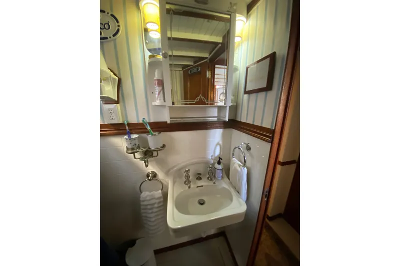 Slide: The Image of Vintage 1939 Elco Motor Yacht bathroom with sink, mirror, and striped wallpaper. - 28