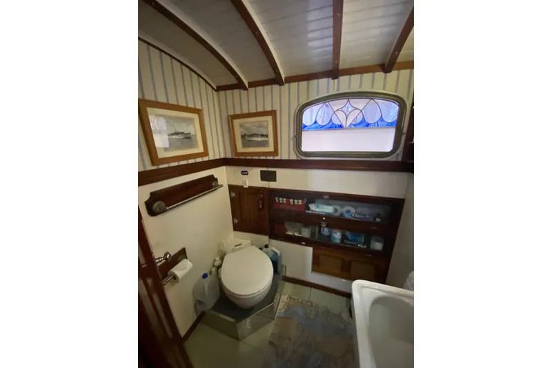 Slide: The Image of 1939 Elco Motor Yacht bathroom with vintage decor and stained glass window. - 29
