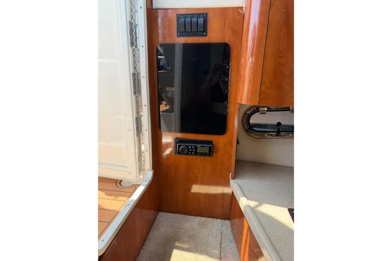 Slide: The Image of Interior view of 2004 Four Winns 268 Vista boat, featuring wood paneling and control panel. - 11