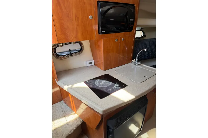 Slide: The Image of Compact kitchen area in 2004 Four Winns 268 Vista boat with sink and microwave. - 14