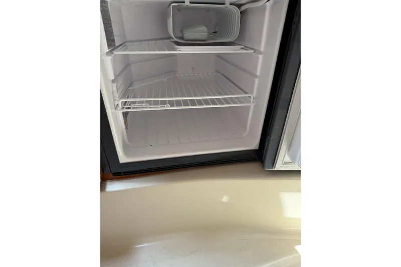 Slide: The Image of Empty refrigerator inside a 2004 Four Winns 268 Vista boat. - 16