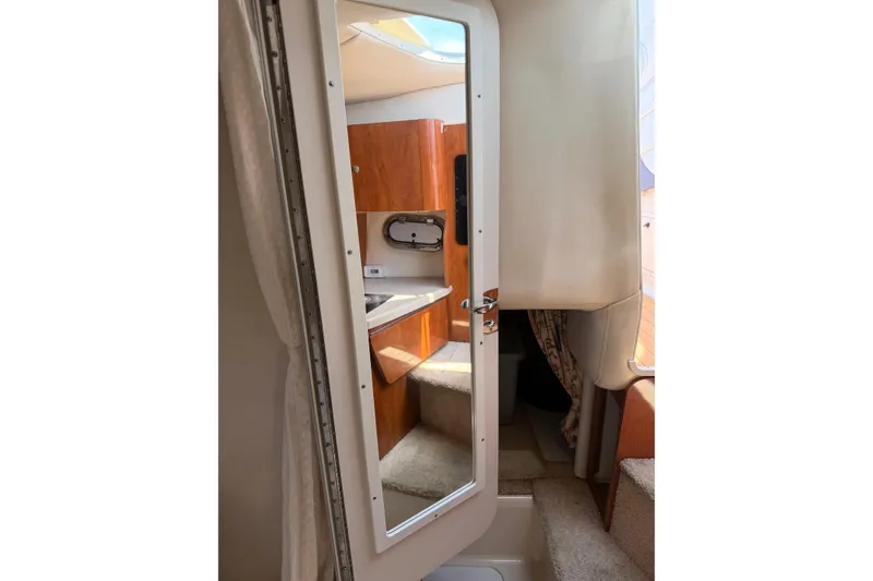 Slide: The Image of Interior view of 2004 Four Winns 268 Vista boat cabin with mirror and wooden cabinetry. - 19