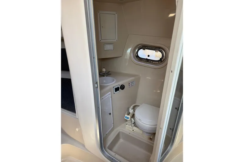 Slide: The Image of 2004 Four Winns 268 Vista boat bathroom with sink, toilet, and porthole window. - 20