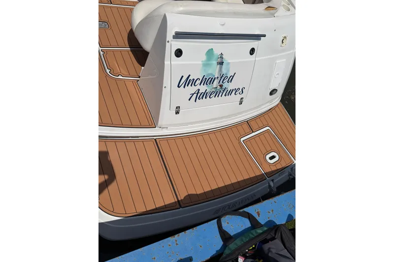 Slide: The Image of 2004 Four Winns 268 Vista boat with "Uncharted Adventures" sign on teak deck. - 3