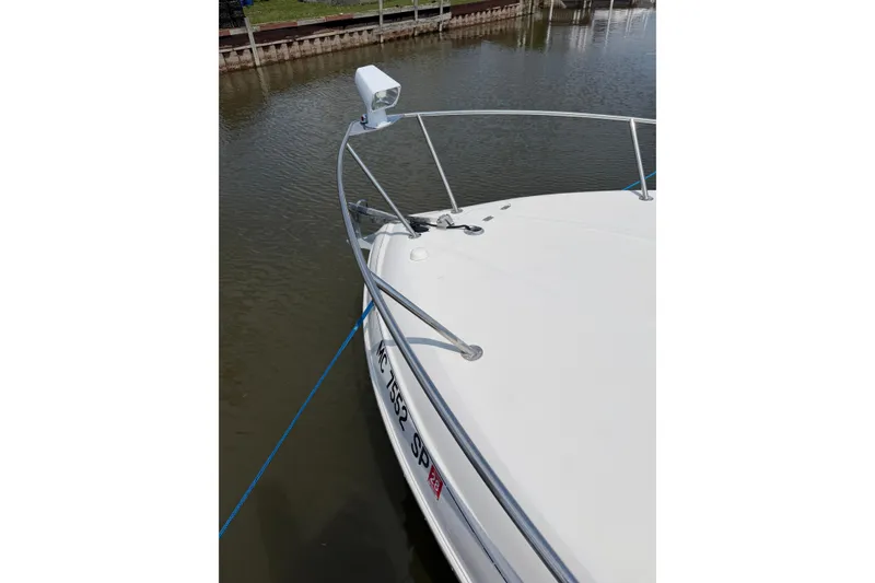 Slide: The Image of 2004 Four Winns 268 Vista boat docked, featuring bow rail and spotlight. - 6