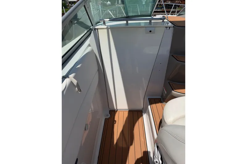 Slide: The Image of 2004 Four Winns 268 Vista boat interior with teak flooring and white seating. - 9