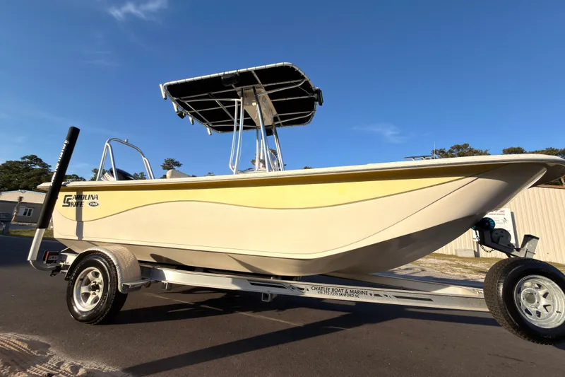 The Image of 2013 Carolina Skiff 198 DLV boat on trailer under clear blue sky. - 0