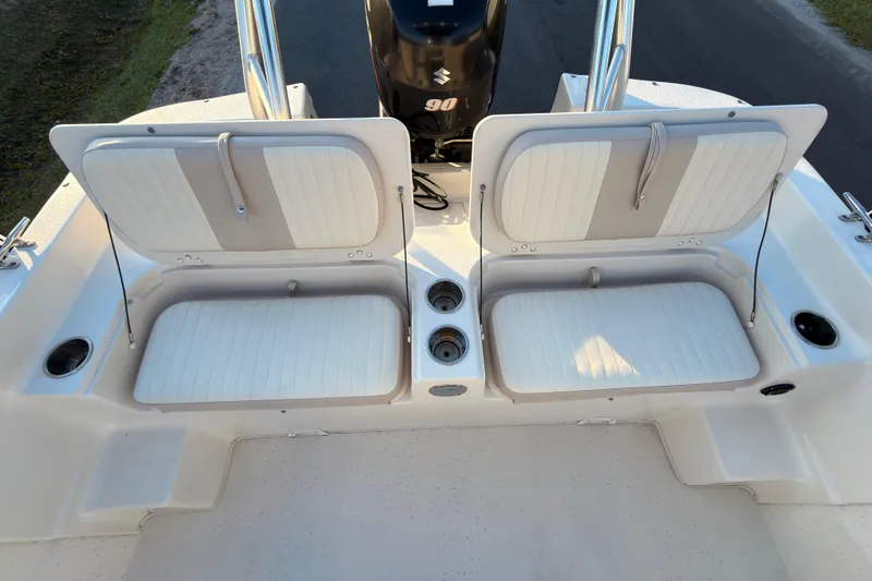 Slide: The Image of 2013 Carolina Skiff 198 DLV boat seating area with storage compartments and Suzuki 90 engine. - 13