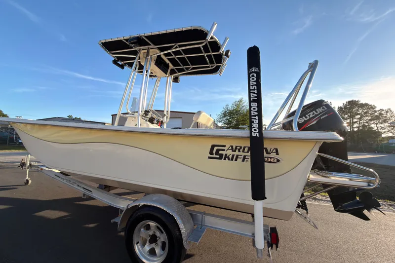 Slide: The Image of 2013 Carolina Skiff 198 DLV boat on trailer with Suzuki outboard motor. - 2