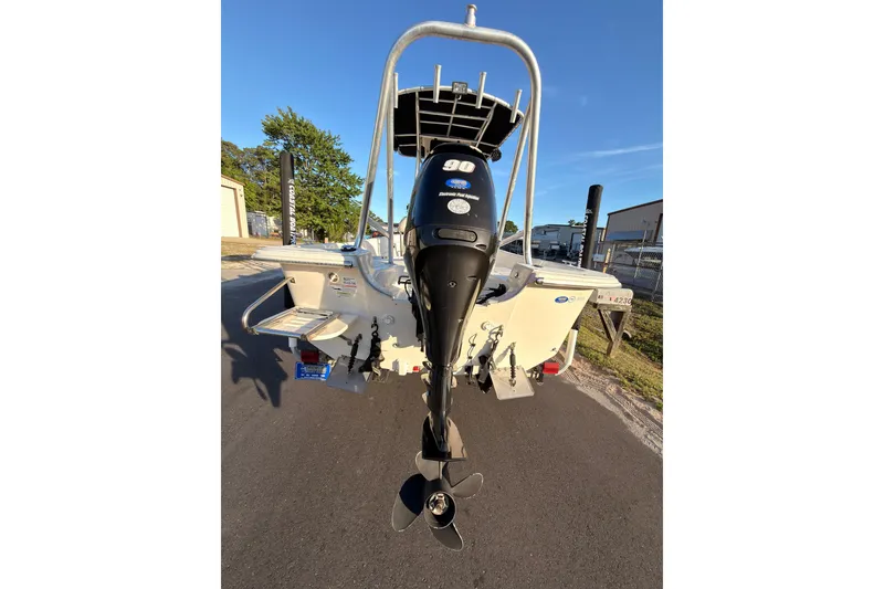 Slide: The Image of 2013 Carolina Skiff 198 DLV boat with 90 HP outboard motor, parked outdoors. - 24