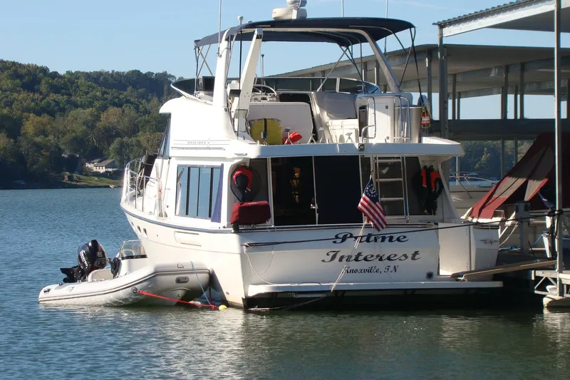 Slide: The Image of 2001 Bayliner 4788 Pilot House Motoryacht docked on a serene lake. - 1