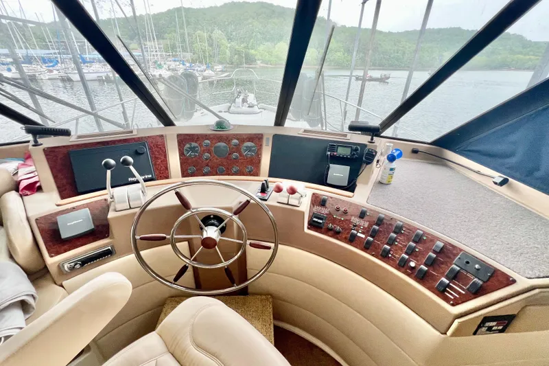 Slide: The Image of 2001 Bayliner 4788 Pilot House Motoryacht helm with steering wheel and control panels. - 12