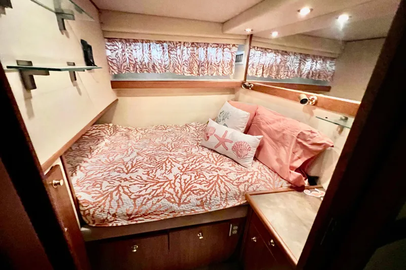 Slide: The Image of Cozy bedroom in 2001 Bayliner 4788 Pilot House Motoryacht with coral-themed decor. - 19