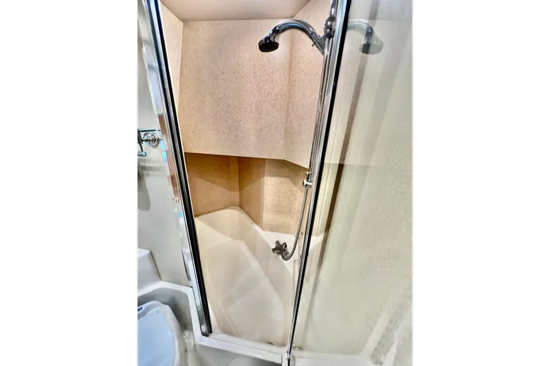 Slide: The Image of Shower area in 2001 Bayliner 4788 Pilot House Motoryacht, featuring glass door and chrome fixtures. - 22