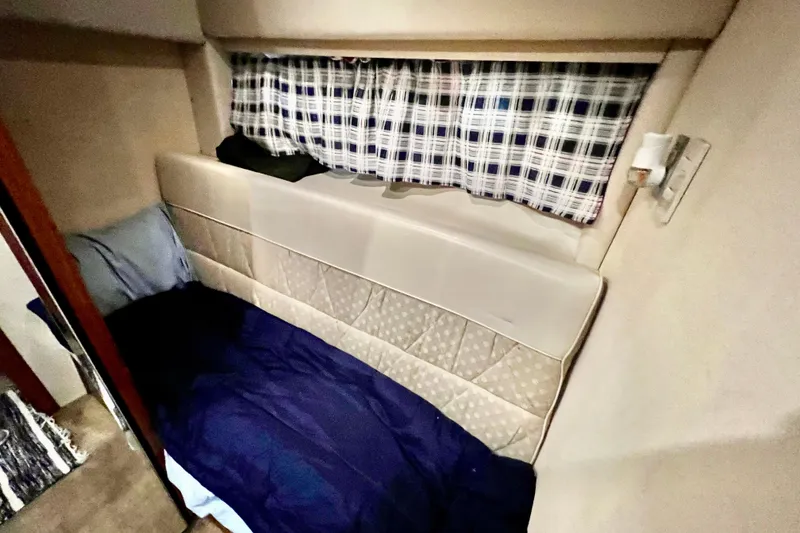 Slide: The Image of Cozy cabin interior of 2001 Bayliner 4788 Pilot House Motoryacht with plaid curtains. - 26
