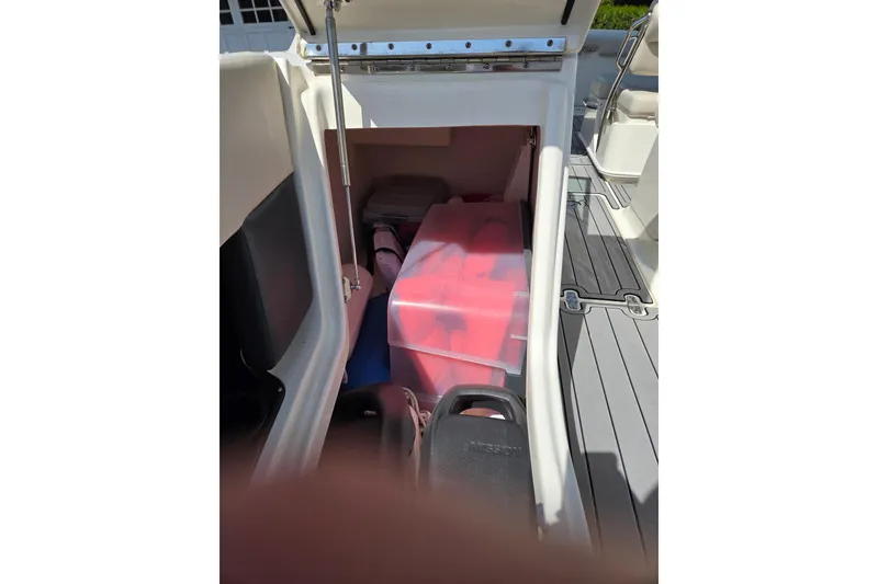 Slide: The Image of Storage compartment of a 2018 Boston Whaler 230 Vantage boat, containing life jackets. - 17