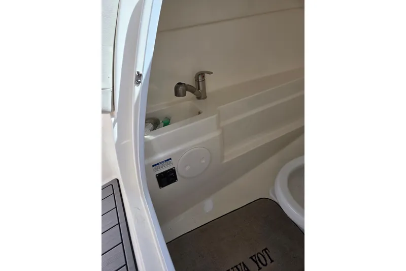 Slide: The Image of Interior view of 2018 Boston Whaler 230 Vantage boat's compact bathroom area. - 23