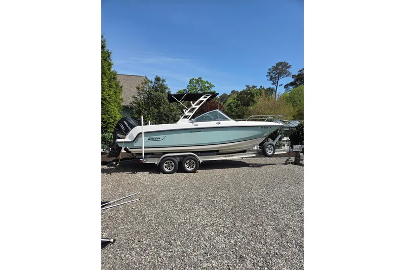 Slide: The Image of 2018 Boston Whaler 230 Vantage boat on trailer, parked outdoors on gravel. - 28