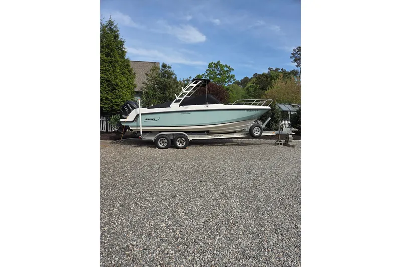 Slide: The Image of 2018 Boston Whaler 230 Vantage boat on trailer in a gravel driveway. - 38