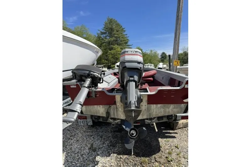 Slide: The Image of 1993 Lund 1700 Pro Angler boat with outboard motor, parked on gravel. - 5