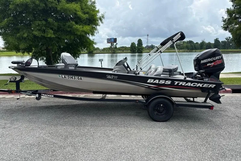 The Image of 2013 Tracker Pro Team 190 TX boat on trailer by a lake. - 0