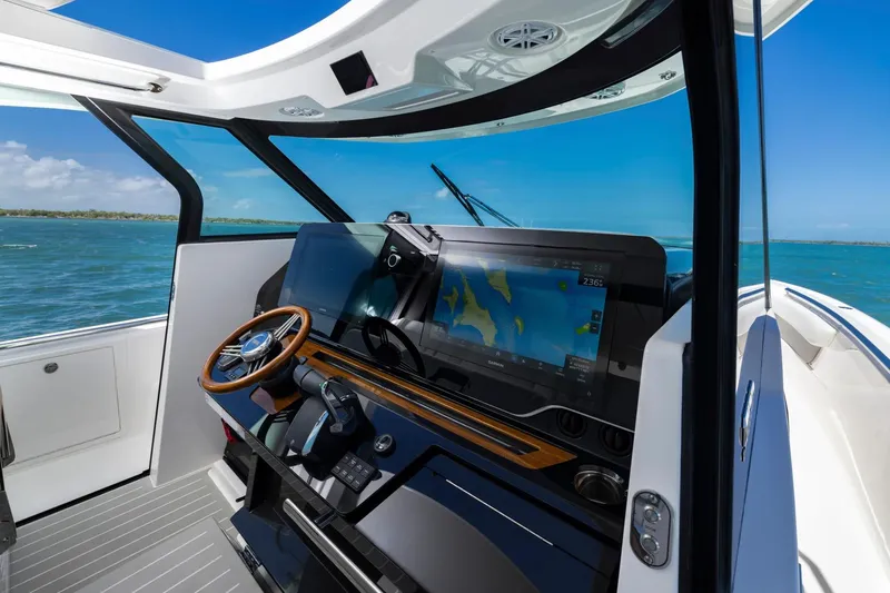 Slide: The Image of Manufacturer Provided Image: Helm of 2026 Tiara Yachts 46 LS with navigation display and wooden steering wheel. - 14