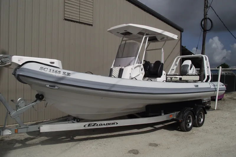 Slide: The Image of 2024 Highfield Sport 760 boat on trailer, parked outdoors, showcasing sleek design and modern features. - 1