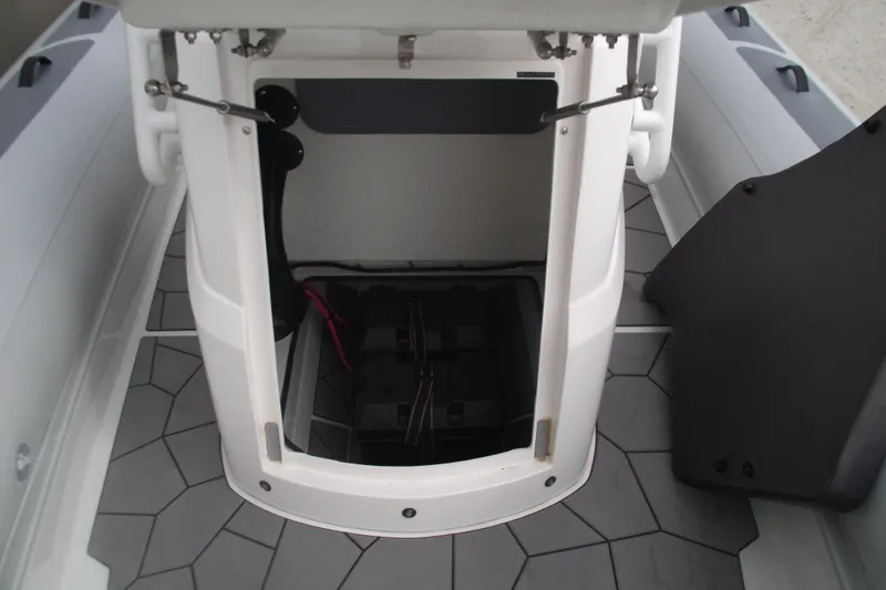 Slide: The Image of 2024 Highfield Sport 760 boat interior storage compartment with open hatch and geometric flooring. - 12