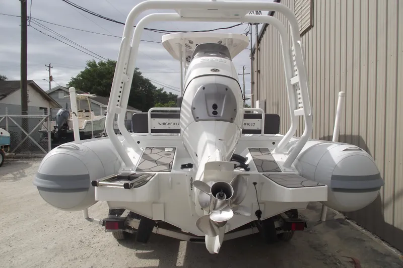 Slide: The Image of 2024 Highfield Sport 760 boat rear view, showcasing engine and inflatable pontoons. - 3