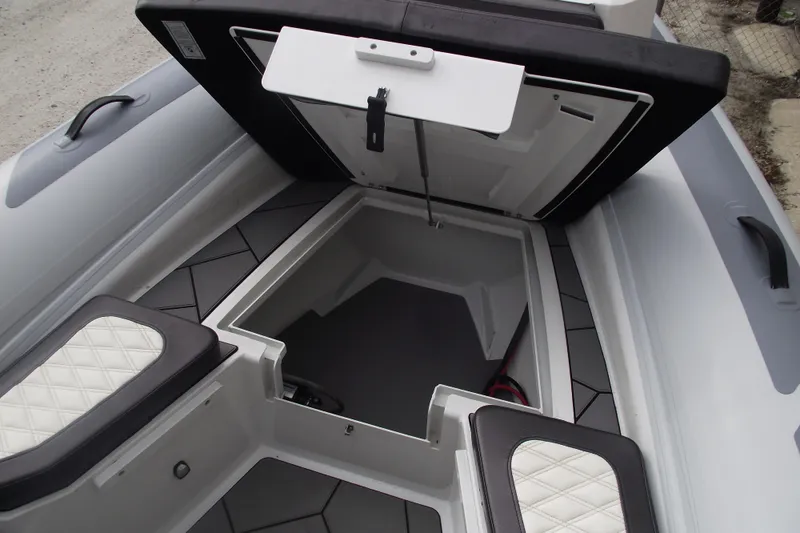 Slide: The Image of 2024 Highfield Sport 760 boat storage compartment with open hatch and cushioned seating. - 9