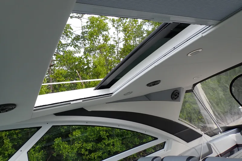 Slide: The Image of 2024 Formula 400 Super Sport Crossover interior with open sunroof, showcasing sleek design and lush greenery. - 18