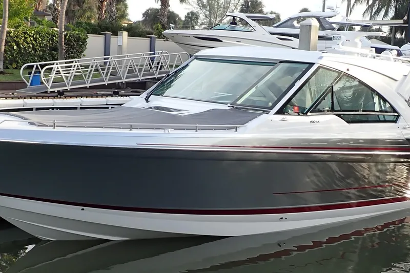Slide: The Image of 2024 Formula 400 Super Sport Crossover boat docked in a marina. - 2