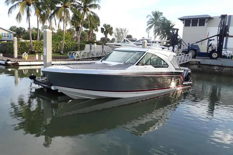 The Image of 2024 Formula 400 Super Sport Crossover boat docked in a marina with palm trees. - 3
