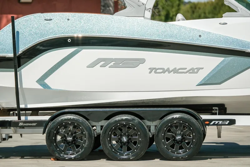 Slide: The Image of 2021 MB F24 Tomcat boat on trailer with sleek design and shiny wheels. - 5