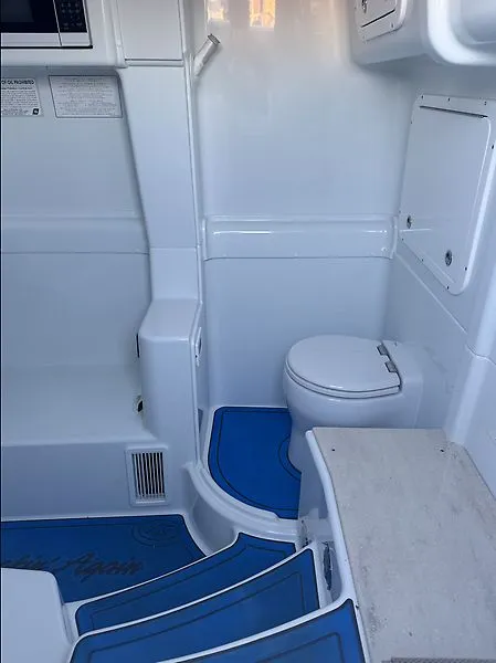 Slide: The Image of Interior of 2022 Yellowfin 42 Offshore with toilet and blue accents. - 11